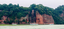 Panorama Shot Of The Ancient Giant Leshan Buddha In Leshan, Chengdu, Sichuan, China, The Largest Stone Carving Of The Buddha In The World, With Three Tour Boats In Front