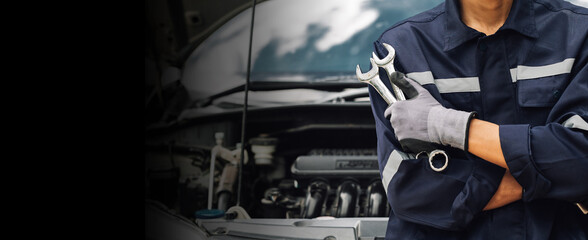 Hand of car mechanic with wrench. Auto repair garage. mechanic works on the engine of the car in the garage. Repair service. Concept of car inspection service and car repair service.