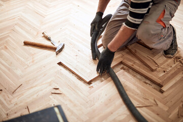 Repairman restoring old parquet hardwood floor.