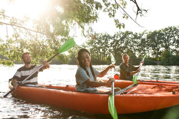 Wall Mural - Happy couple kayaking on the river surrounded by trees, enjoying adventurous experience