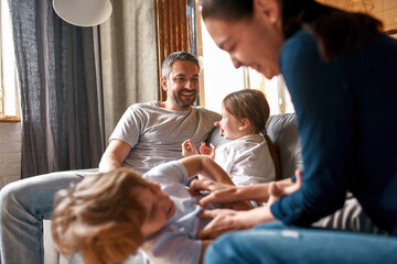 Wall Mural - Overjoyed family with small kids play at home