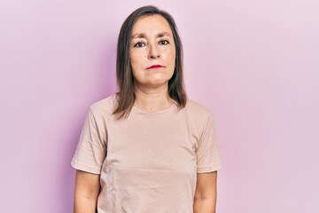 Wall Mural - Middle age hispanic woman wearing casual clothes relaxed with serious expression on face. simple and natural looking at the camera.