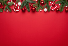 Red Background With Christmas Decorations Of Fir Branches And Christmas Balls
