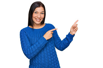 Poster - Young hispanic woman wearing casual clothes smiling and looking at the camera pointing with two hands and fingers to the side.