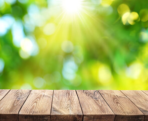 Wall Mural - Bokeh sunny nature background and wood board in foreground. File contains board clipping path. It is possible to place your product.