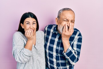 Wall Mural - Hispanic father and daughter wearing casual clothes laughing and embarrassed giggle covering mouth with hands, gossip and scandal concept