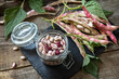Beans of bean, brown bean (of dried beans) in a glass jar on a rustic table. Food background.