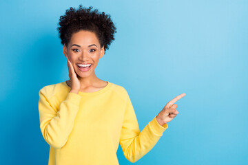 Photo portrait curly woman smiling amazed showing copyspace isolated pastel blue color background