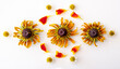 Marigold petals, yellow rudbeckia hirta flowers and daisies, laid out in a pattern on a white background.