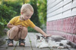 Little boy playing with a cat outdoors.
