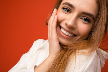 Wall Mural - Closeup portrait of young smiling beautiful dark blonde woman with sincere emotions isolated on background wall with copy space wearing casual white hoodie. Positive concept