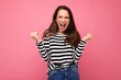 © Ivan Traimak - Portrait of young positive happy beautiful brunette woman with sincere emotions wearing casual striped pullover isolated on pink background with empty space and celebrating victory saying yeah