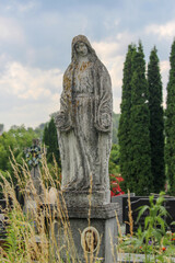 Wall Mural - Stone sculpture on the grave in a Christian cemetery