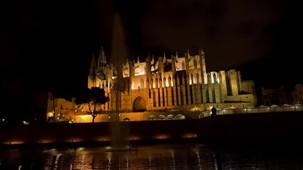 Wall Mural - Night static shot of the Cathedral of Palma de Mallorca (La Seu) with fountain in the foreground - Spain