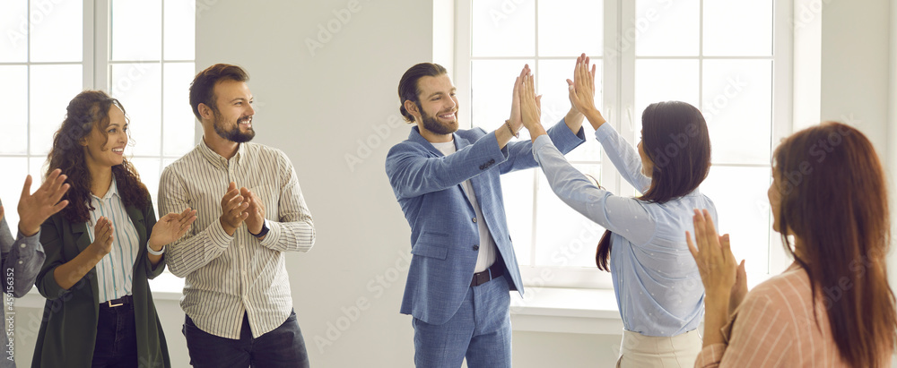 Two happy cheerful business people give each other a high five while ...