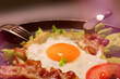 Fried eggs - the dish prepared on a frying pan from the broken eggs. A traditional breakfast in Great Britain and Ireland - fried eggs with bacon.