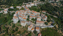 Aerial View Of The Village Of Sainte Lucie De Tallano In The Mountains Of Southern Corsica, France - Round Shaped Medieval Village With Old Houses Surrounded By Pine Forests