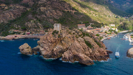 Wall Mural - Aerial view of the ruins of the square Genoese tower of Porto at the end of the Gulf of Porto, Corsica, France - Remains of a medieval watchtower overlooking the Mediterranean Sea