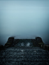 Moody Long Duration Shot Of Concrete Steps Leading Down To The Sea With Copy Space