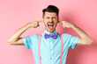 © Mix and Match Studio - Irritated young man block noise, shut ears with hands and screaming annoyed, being disturbed by loud sound, standing over pink background