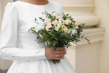 Wall Mural - Bride wearing engagement ring and wedding dress with beautiful bouquet outdoors, closeup