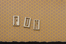 The Word "fun" In Wooden Stencil Font On Polka Dot Paper