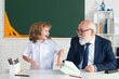 © Volodymyr - Old senior teacher and school boy pupil. Education in elementary school, kids learning concept.