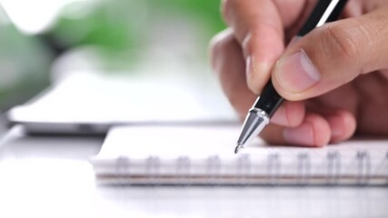 Poster - Closeup hand of businessman writing on notebook at home, businessman working on table.