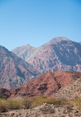 Sticker - Vertical shot of beautiful mountains under a blue sky on a sunny day