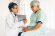 © Art_Photo - Senior woman doctor wearing uniform with stethoscope service help support discussing and consulting talk to sick woman patient about checkup result information with tablet computer in hospital