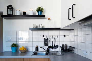 Wall Mural - Kitchen with white tiles, kitchen counter top, cabinet, shelves and utensils. Cozy and scandinavian interior of room at home. Hotel.