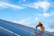 © visoot - Solar panel technician with drill installing solar panels on roof at solar panel field,Environmental protection,Alternative clean green energy concept.