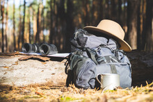 Tourist Backpack, Hat, Binoculars And A Map On A Log In The Forest. Concept Hiking, Hiking In The Mountains