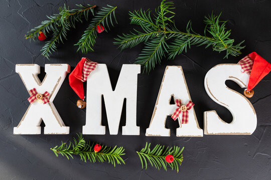 Vintage wooden word Xmas, rustic style. Wooden letter on black background, word XMAS, classic Christmas decoration