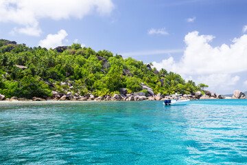 Wall Mural - Seychelles, motor boat against the tropical backdrop of the rocky island.