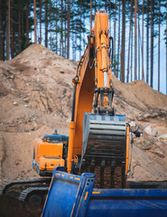 Wall Mural - Yellow heavy excavator and bulldozer excavating sand and working during road works, unloading sand during construction of the new road