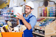 © JackF - Focused cheerful positive workman choosing materials for renovation works in paint store