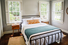 A Guest Bedroom With A Queen Sized Bed And Nightstand At A Short Term Rental Small Cottage Style House