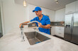 © spatesphoto - Plumber working on a kitchen faucet