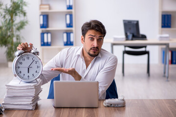 Wall Mural - Young male employee in time management concept