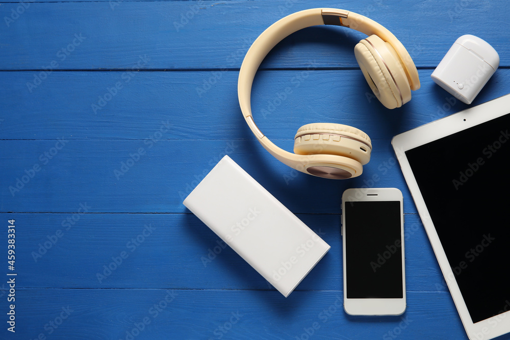 Different modern devices on color wooden background