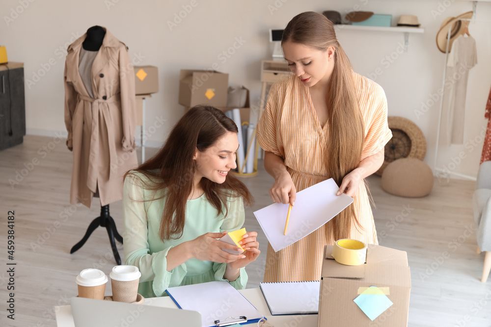 Female business owner and seller processing order in shop