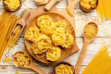 Different Types Of Uncooked Pasta On Wooden Background