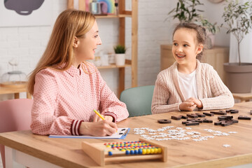 Wall Mural - Female psychologist working with girl suffering from autistic disorder in office