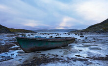 Lonely Boat At Low Tide On The Shore Of The Barents Sea At Sunset