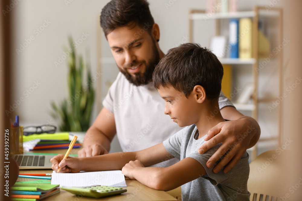 Little boy with his father doing lessons at home