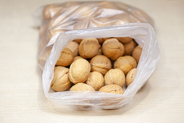 Aufkleber - A lot of whole walnuts in a bag on a white background. Healthy, organic food with a high content of protein and protein.
