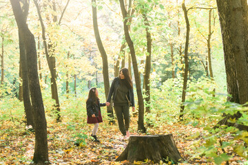 Wall Mural - Mother and her little daughter in autumn park in fall season.