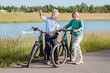 © Westend61 - Senior man pointing while talking with woman standing by bicycles