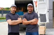 © Westend61 - Smiling male delivery persons with arms crossed near van